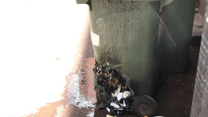 A wheelie bin left trashed after being set on fire.