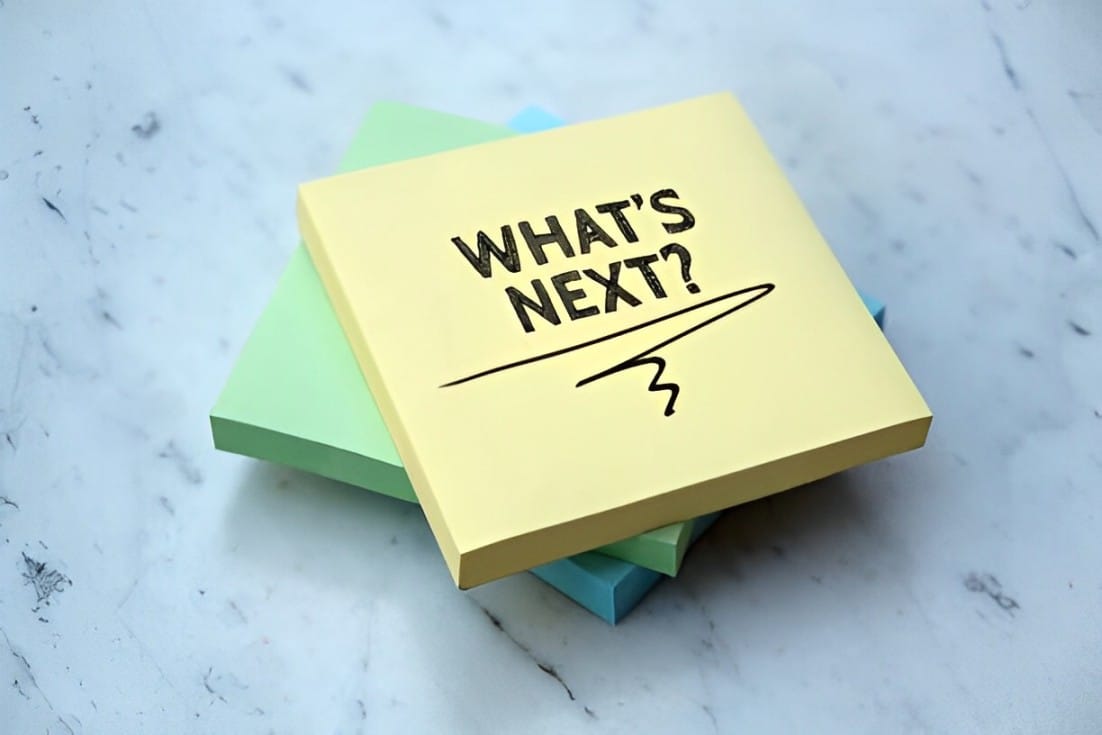 The phrase "What's next" written on a yellow notepad