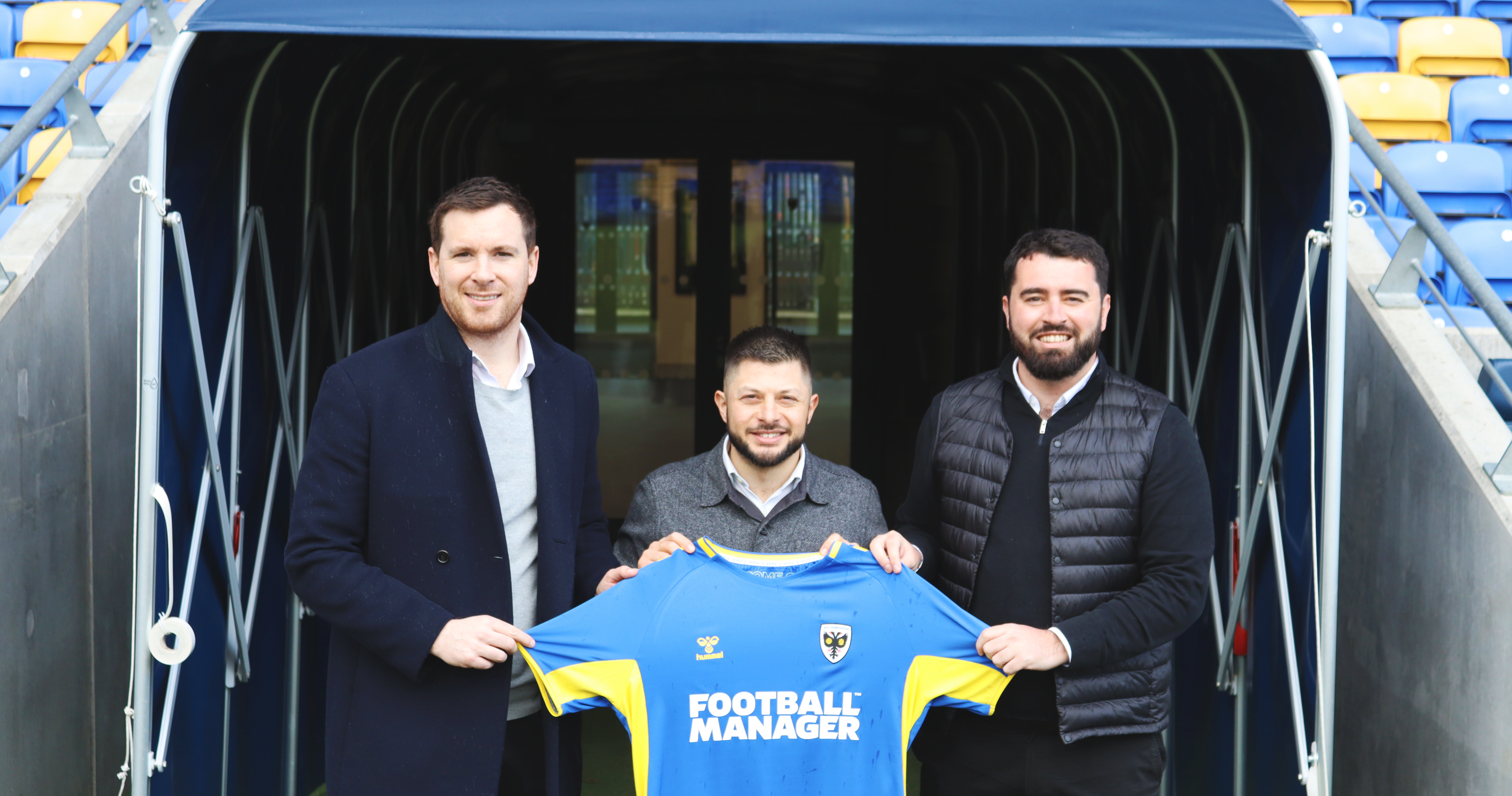 Jack Butler, Pietro Palladino & Guy Davis holding an AFC Wimbledon shirt.