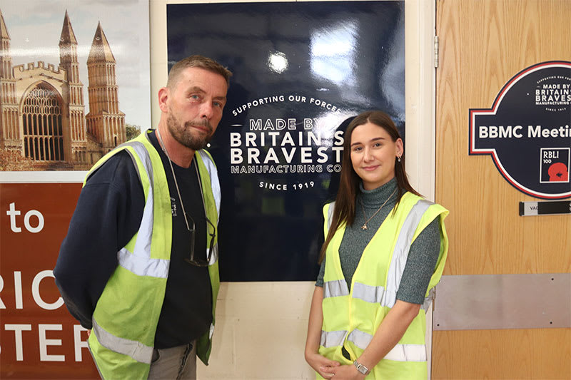 Molly Saxby (Content Marketing Exec at Seat Unique) with Jeff in front of Britain's Bravest Manufacturing Company sign