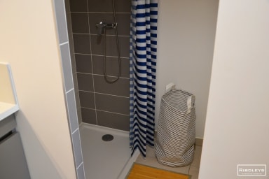 Salle de bain avec douche et machine à laver