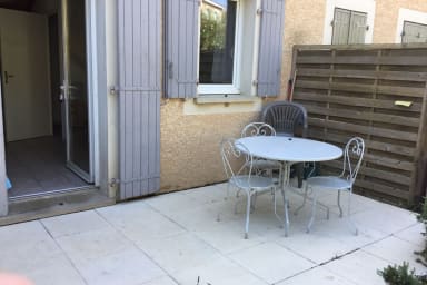 Patio area outside house. There are also two deck chairs and a large parasol...