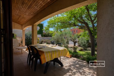 Terrasse ombragée avec espace repas et barbecue charbon