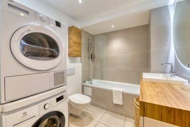Salle de bain avec machine à laver le linge et sèche linge