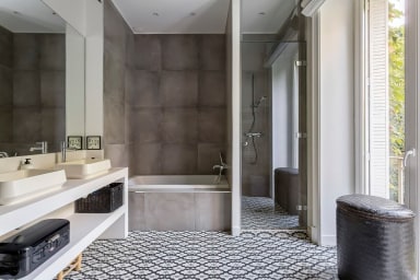 Troisième salle de bain équipée de trois vasques, d'une douche et d'une...