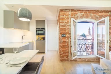 cuisine et salon avec fenêtres donnant sur les toits de Toulouse