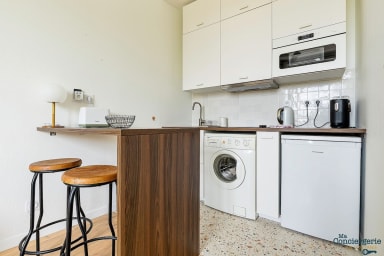 Espace cuisine avec machine à laver, micro-ondes, bouilloire, cafetière et...