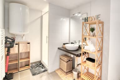 Salle d'eau avec douche, WC et des étagères de rangement