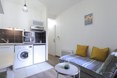 Espace de séjour avec coin salon, tv, coin repas et kitchenette équipée 