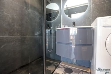 Salle d'eau avec machine à laver, sèche cheveux, fer à lisser