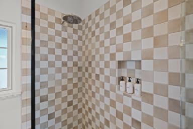 En-suite bathroom with rain shower and Public Goods toiletries.