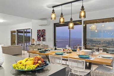 Evening sets the mood in this elegant dining space with sea views.