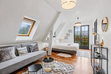 Chambre élégante avec coin salon et accès balcon pour une pause en douceur.
