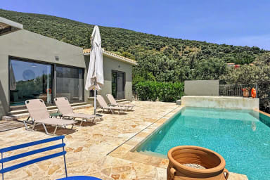 Détendez-vous près de la piscine entourée de montagnes, jardins et transats.