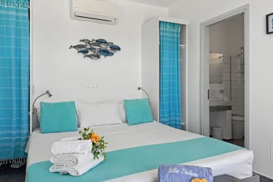 Lits préparés avec linge frais, serviettes et touches florales.