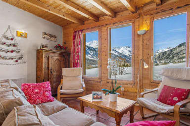 Soggiorno accogliente con vista panoramica sulla montagna innevata.