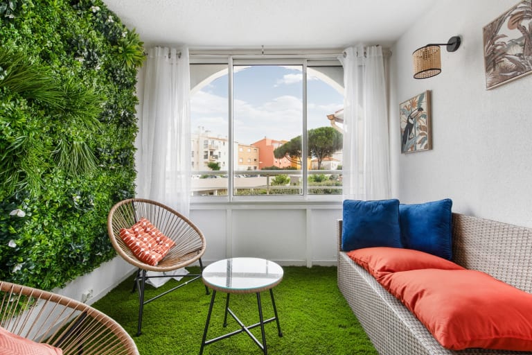 Loggia aménagée de Marina Bay avec mur végétal, fauteuils et banquette, quartier des Falaises au Cap d'Agde