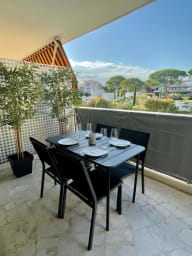 Terrasse spacieuse et ensoleillée, aménagée avec une table et des chaises...