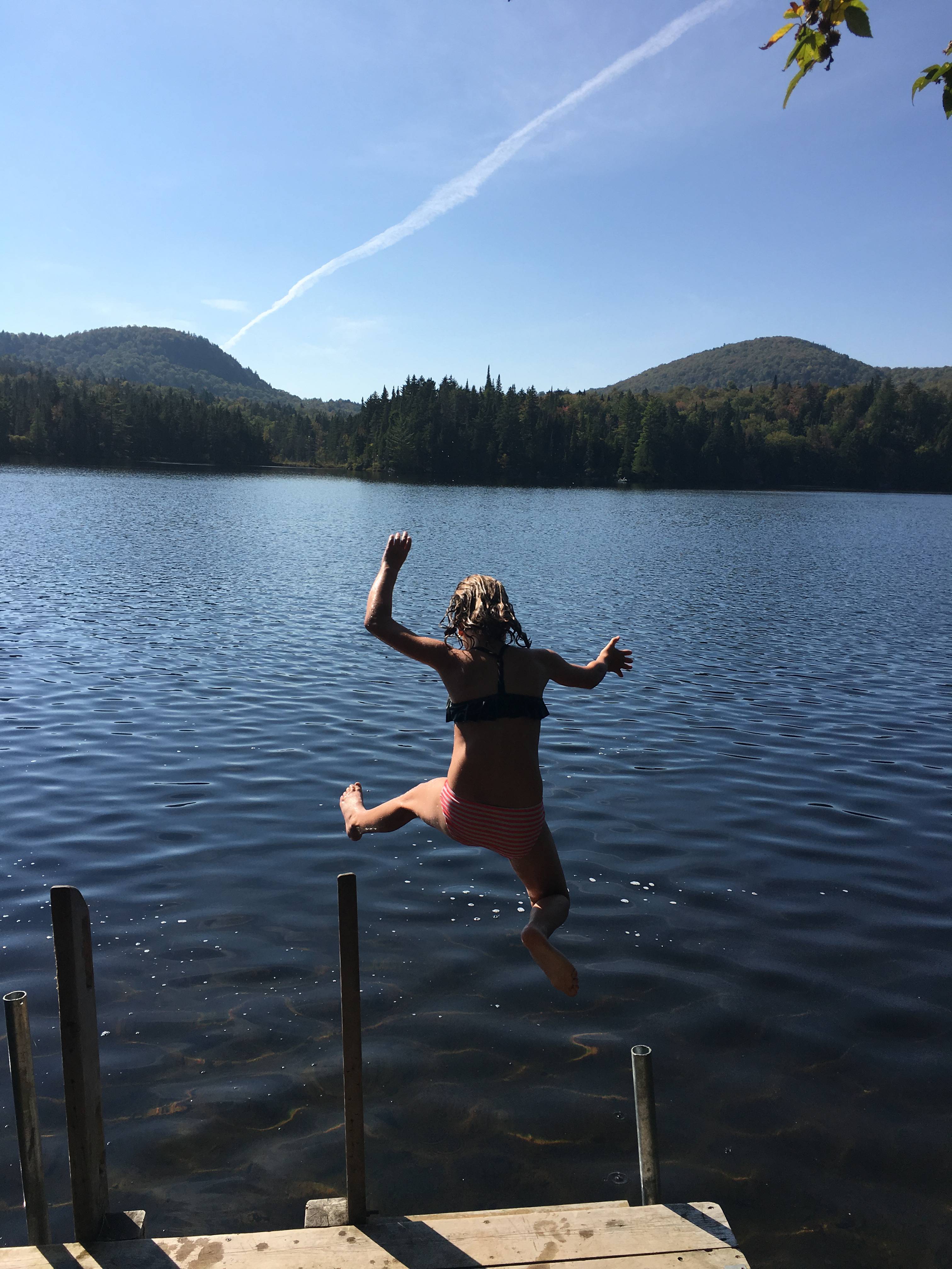 A child jumping into the lake at Les Refuges Perchés