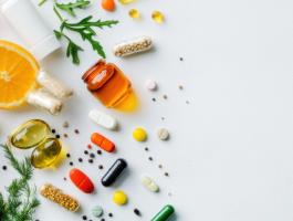 Verschiedene Nahrungsergänzungsmittel, frisches Gemüse, Obst und Samen auf weißem Hintergrund, symbolisch für gesunde Ernährung und Supplementierung.