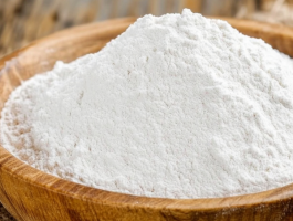 Holzschale mit feinem, weißem Proteinpulver auf Jutesack – Symbolbild für veganes Eiweiß aus pflanzlicher Quelle, z. B. Reis- oder Erbsenprotein in Pulverform.