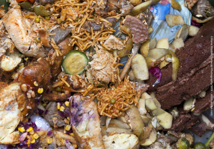 Ein Haufen mit verschiedenen Arten von Küchenabfällen, einschließlich Nudeln, Gemüse, Kartoffeln, Fleisch und Brot, die teilweise gegessen wurden und sich in Zersetzung befinden.