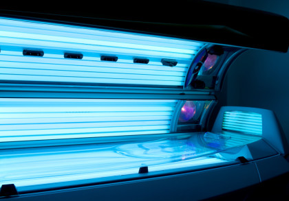 Ein Solarium mit eingeschaltetem blauem UV-Licht in einem dunklen Raum.