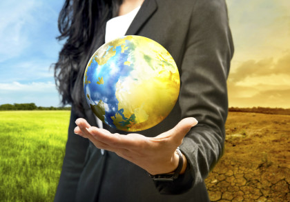 Eine Person in einem Anzug hält eine schwebende Weltkugel in der Hand. Der Hintergrund ist zweigeteilt: links eine grüne Wiese und blauer Himmel, rechts ausgetrocknete, rissige Erde und ein gelblicher Himmel.