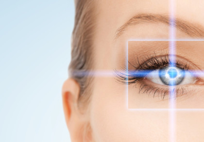 Nahaufnahme eines Auges mit blauer digitaler Zielanzeige über der Iris, die von einer weißen Box eingerahmt ist. Der Hintergrund ist hell und unscharf.