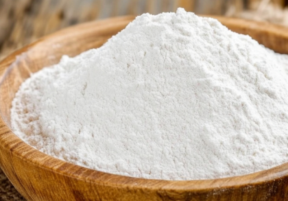 Holzschale mit feinem, weißem Proteinpulver auf Jutesack – Symbolbild für veganes Eiweiß aus pflanzlicher Quelle, z. B. Reis- oder Erbsenprotein in Pulverform.