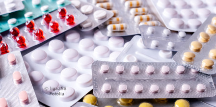 Verschiedene Blisterpackungen mit Tabletten und Kapseln in unterschiedlichen Farben (weiß, rosa, gelb, rot). Die Packungen sind überlappend angeordnet und bilden einen unordentlichen Haufen.
