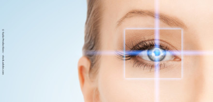 Nahaufnahme eines Auges mit blauer digitaler Zielanzeige über der Iris, die von einer weißen Box eingerahmt ist. Der Hintergrund ist hell und unscharf.