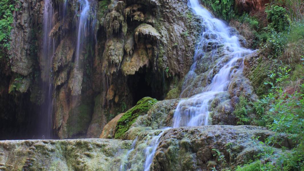 a large waterfall next to a rock