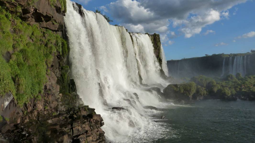 a waterfall with a mountain in the background