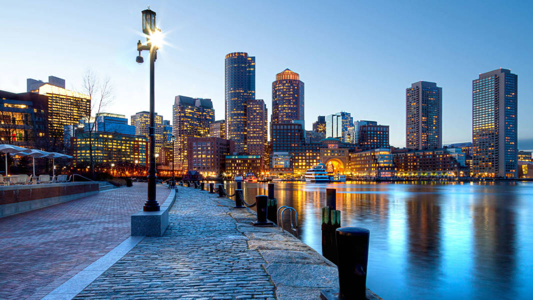 a bridge over a body of water with a city in the background