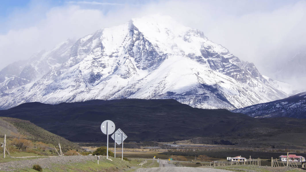 a sign on the side of a snow covered mountain