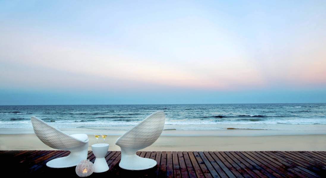 a bird sitting on a beach near a body of water