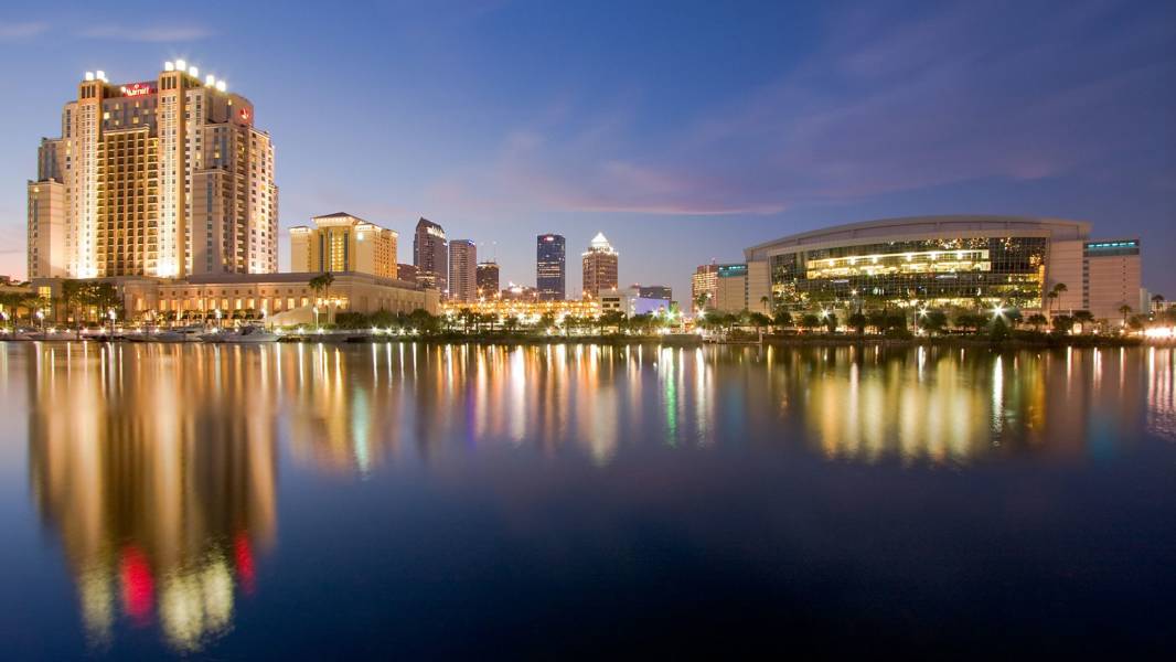 a bridge over a body of water with a city in the background