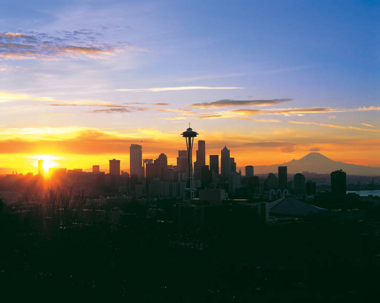 a sunset over a body of water with a city in the background