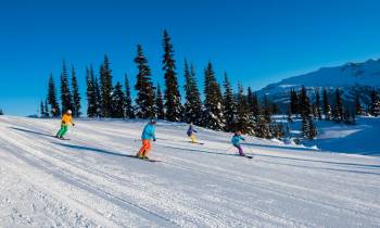 a group of people riding skis on top of a snow covered slope