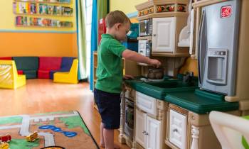 a little boy that is standing in the kitchen