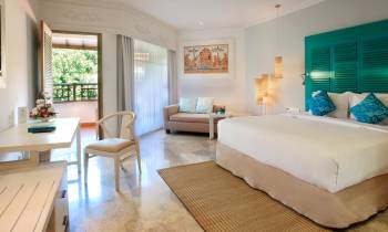 a bedroom with a bed and a chair in a room