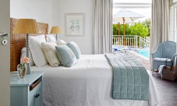 a bedroom with a bed and a chair in a room