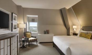 a bedroom with a bed and desk in a room