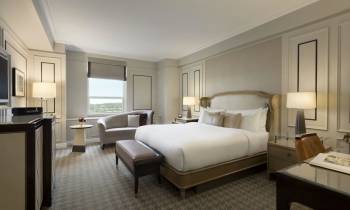 a bedroom with a bed and desk in a hotel room