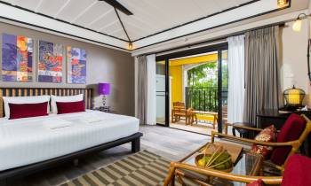 a bedroom with a bed and a chair in a room