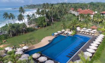 a large lawn in front of a pool of water
