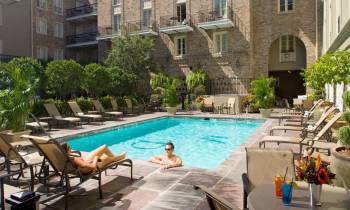 a person sitting at a table in front of a pool