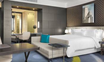 a bedroom with a bed and desk in a room