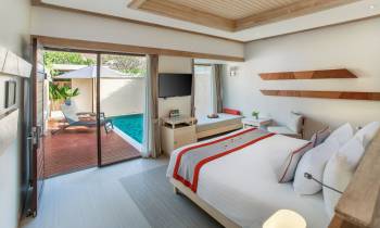 a bedroom with a bed and desk in a room